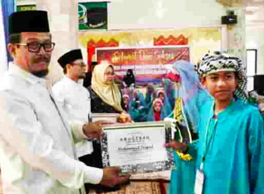 Kakan Kemenag Ustad Alizar Chan saat serahkan Anugrah Tahfiz pada salah seorang santri di Khatam Alquran TPQ Mesjid Raya Jihad, Ahad (26/5/2024) siang.